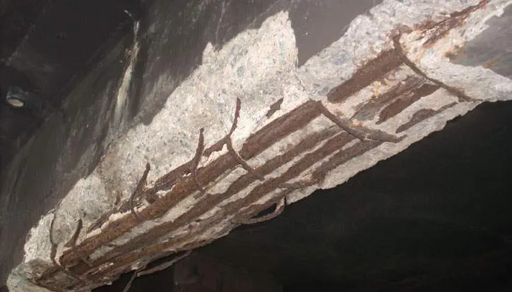 Laje de concreto com o cobrimento solto e as barras de aço enferrujadas à mostra